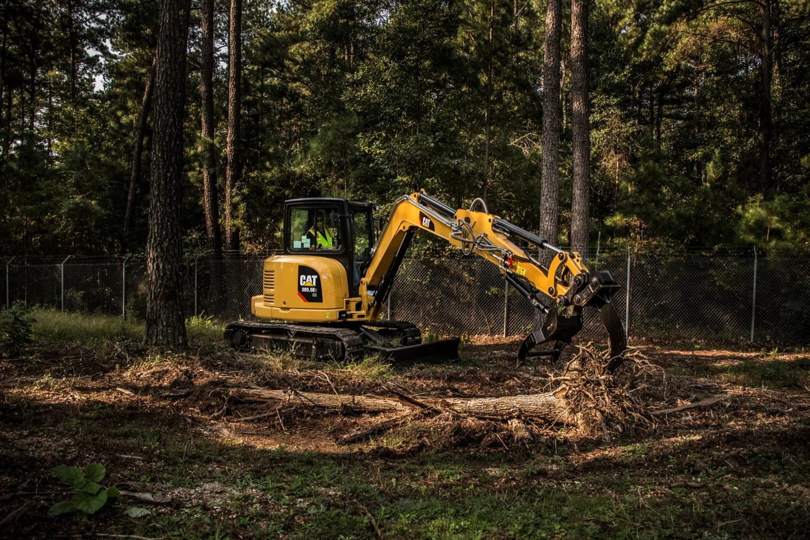 Machine pulling brush off a wooded lot