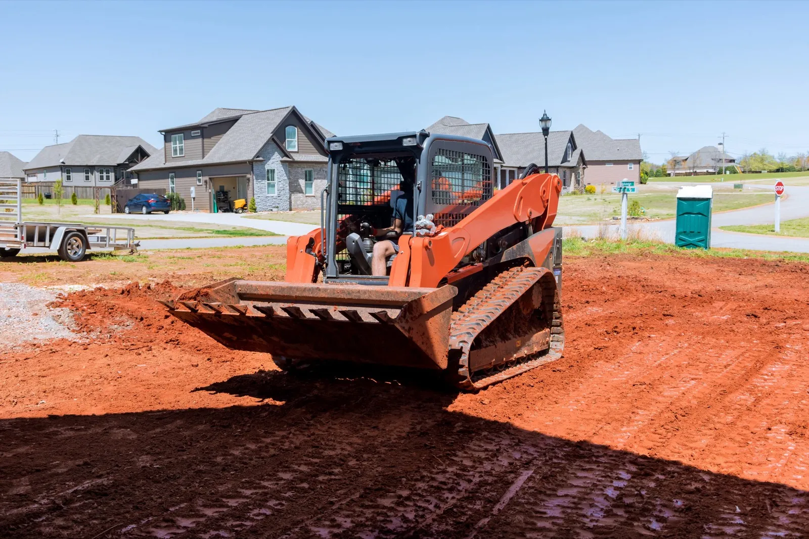 Skid steer grading a residential site